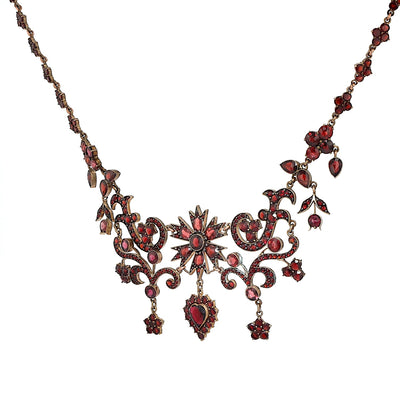 Antique and unusual garnet necklace made of tombac, gold-plated, hanging, twisted left