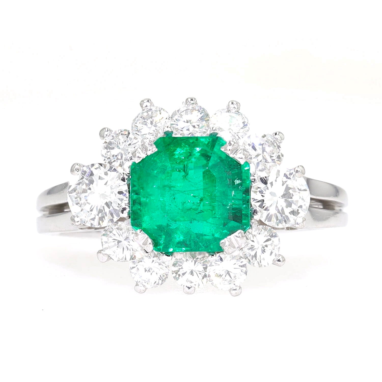 Entourage ring in 750 white gold with a Colombian emerald weighing approx. 1.7 ct and approx. 1.0 ct brilliants, lying frontally